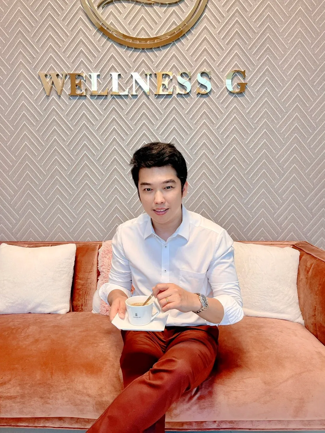 ทีมงาน Wellness G นั่งหน้าป้ายโลโก้ในสำนักงานของโรงงานรับผลิตอาหารเสริม OEM
